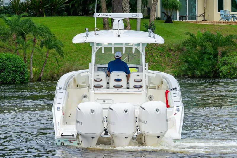 Slide: The Image of 2020 Cobia 350 CC boat with triple Yamaha engines on a scenic waterway. - 9