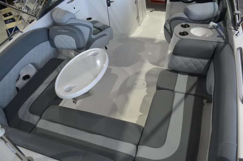 Slide: The Image of Interior of 2026 NauticStar 243 DC Deck boat with gray seating and table. - 12