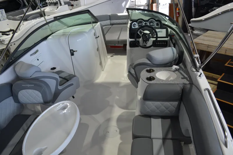 Slide: The Image of 2026 NauticStar 243 DC Deck boat interior with gray seating and modern dashboard. - 13
