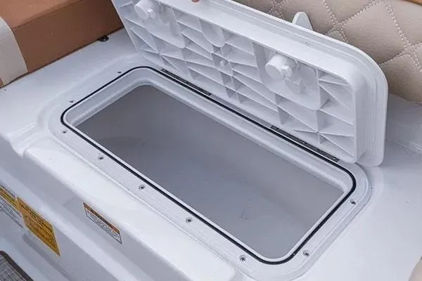 Slide: The Image of 2026 NauticStar 243 DC Deck boat interior with storage compartment and cooler. - 8