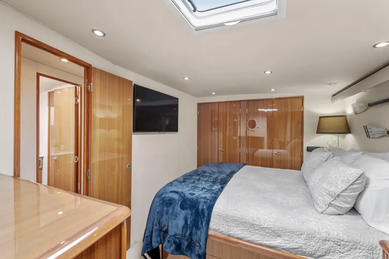 Slide: The Image of Luxurious 2005 Viking 61 Convertible yacht bedroom with modern amenities and elegant wood finishes. - 20