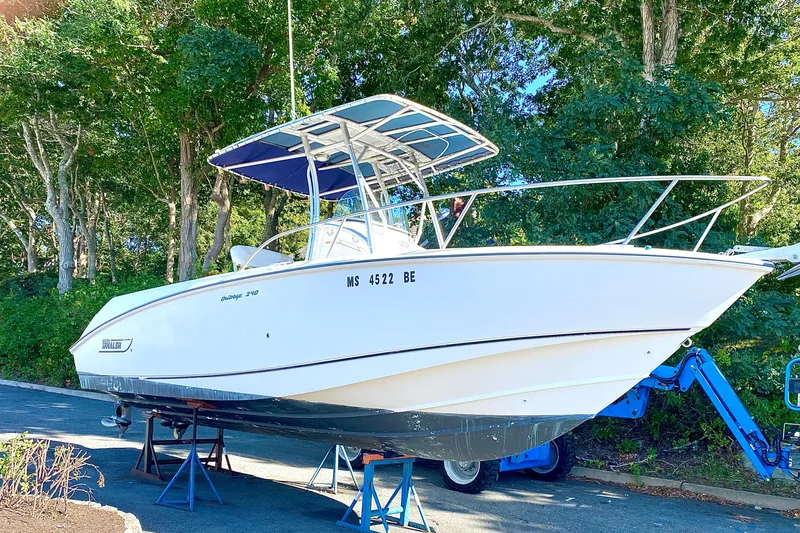 The Image of 2003 Boston Whaler 240 Outrage boat on stands, surrounded by trees. - 0