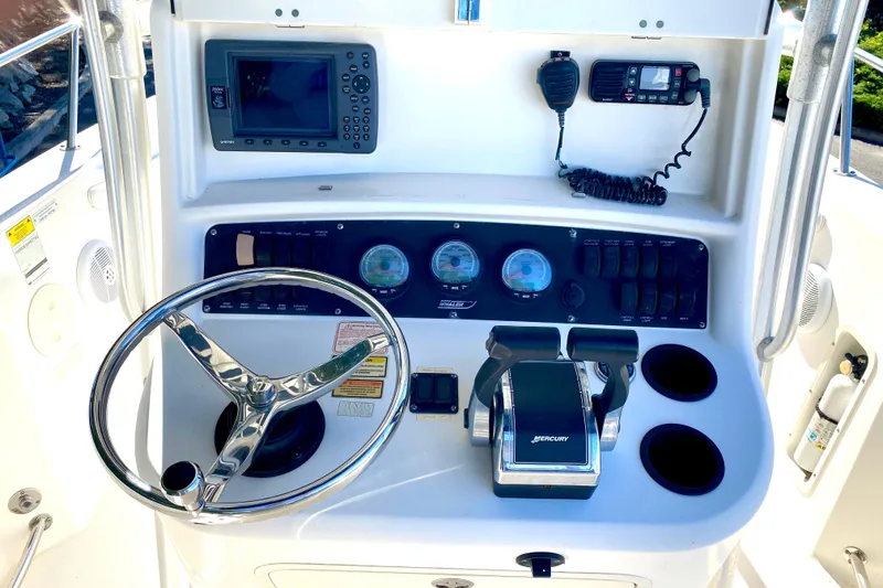 Slide: The Image of Boston Whaler 240 Outrage 2003 boat dashboard with steering wheel and controls. - 2