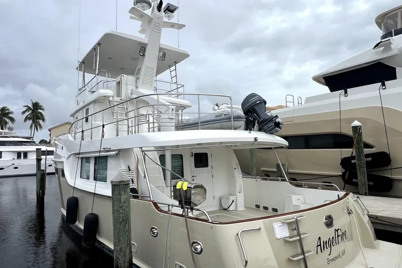 Slide: The Image of 2011 Nordhavn 60 yacht docked at marina, featuring spacious deck and modern design. - 1