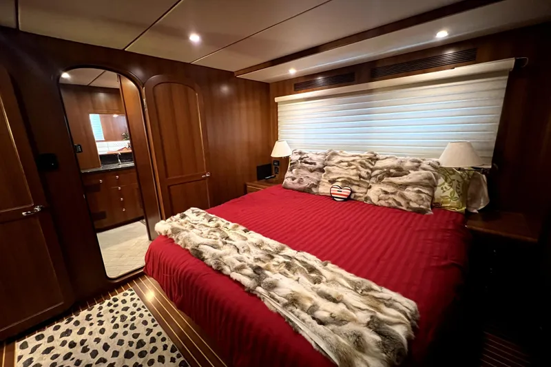 Slide: The Image of Luxurious 2011 Nordhavn 60 yacht bedroom with red bedding and wood paneling. - 16