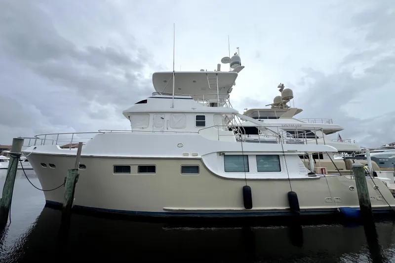 Slide: The Image of 2011 Nordhavn 60 yacht docked at marina under cloudy sky. - 2