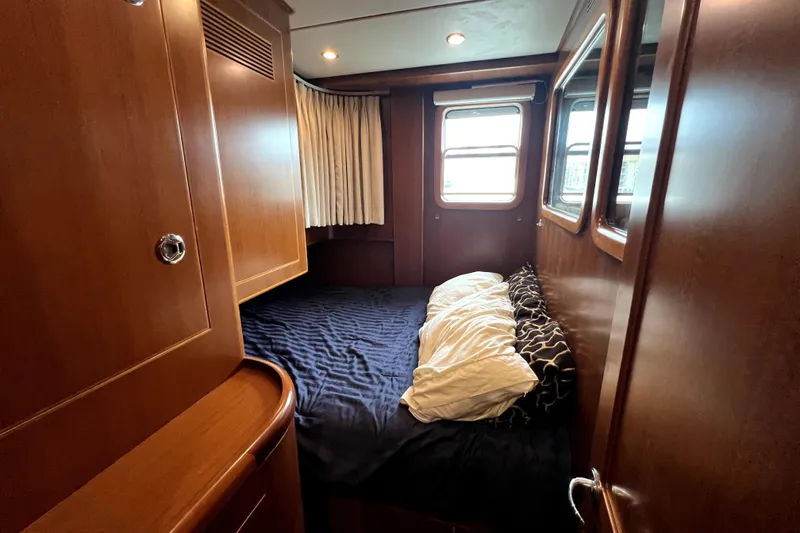 Slide: The Image of Cozy cabin interior of 2011 Nordhavn 60 yacht with wooden finish and comfortable bedding. - 27