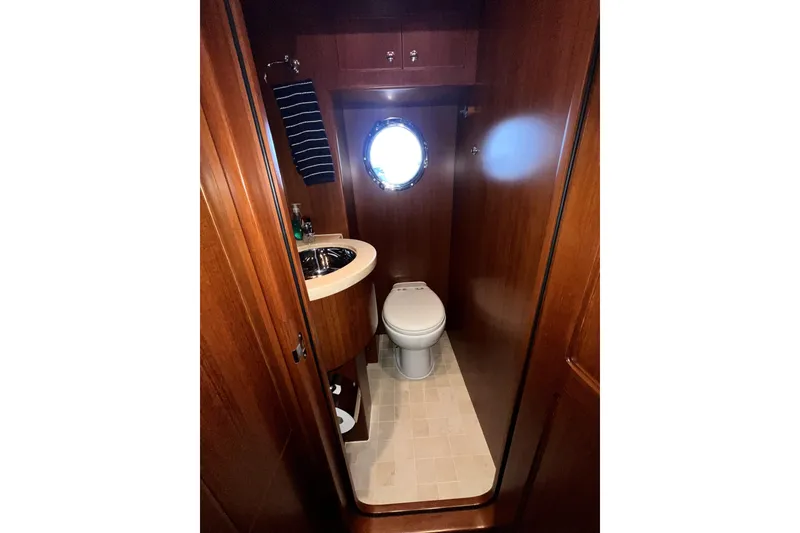 Slide: The Image of Luxurious 2011 Nordhavn 60 yacht bathroom with wooden cabinetry and porthole window. - 28