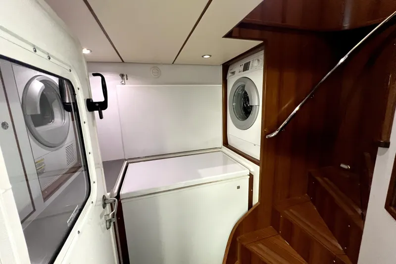 Slide: The Image of Laundry area in 2011 Nordhavn 60 yacht with washer, dryer, and wooden stairs. - 29