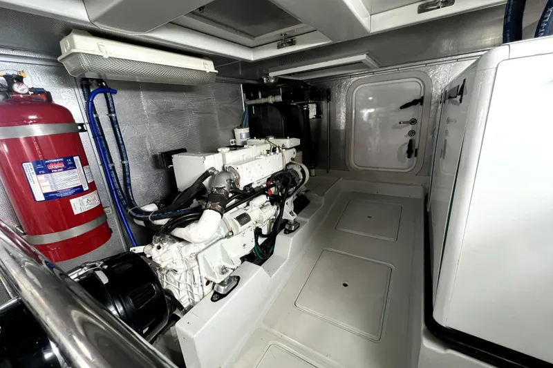 Slide: The Image of Engine room of a 2011 Nordhavn 60 yacht, featuring machinery and fire extinguisher. - 32