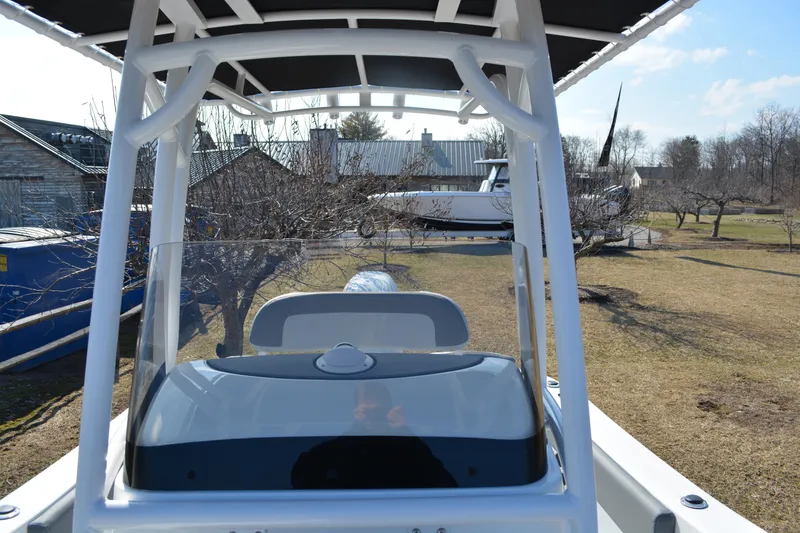 Slide: The Image of 2026 NauticStar 212 Legacy boat console with T-top in a yard setting. - 18