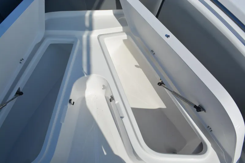 Slide: The Image of 2026 NauticStar 212 Legacy boat storage compartments open, showcasing spacious interior design. - 22