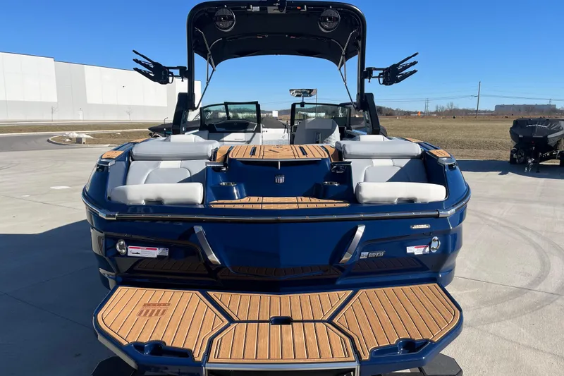 Slide: The Image of 2025 MasterCraft X24 boat with sleek design and spacious seating, parked outdoors. - 5