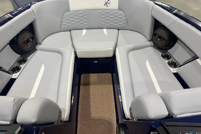 Slide: The Image of 2025 MasterCraft X24 boat interior with gray seating, cup holders, and speakers. - 9