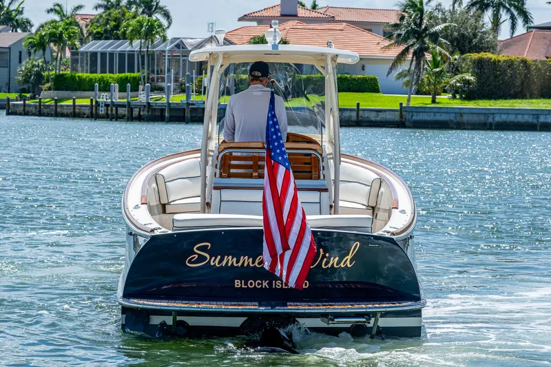 Slide: The Image of 2003 Hinckley Talaria 29 Center Console boat on water, American flag, sunny day. - 1