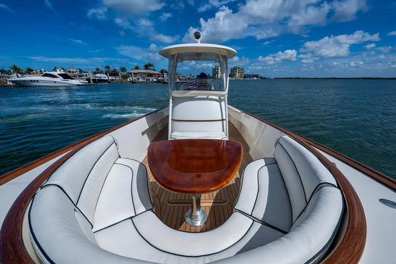 Slide: The Image of 2003 Hinckley Talaria 29 Center Console boat with elegant seating and wooden table on open water. - 10