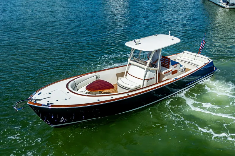 Slide: The Image of 2003 Hinckley Talaria 29 Center Console boat cruising on clear blue water. - 2