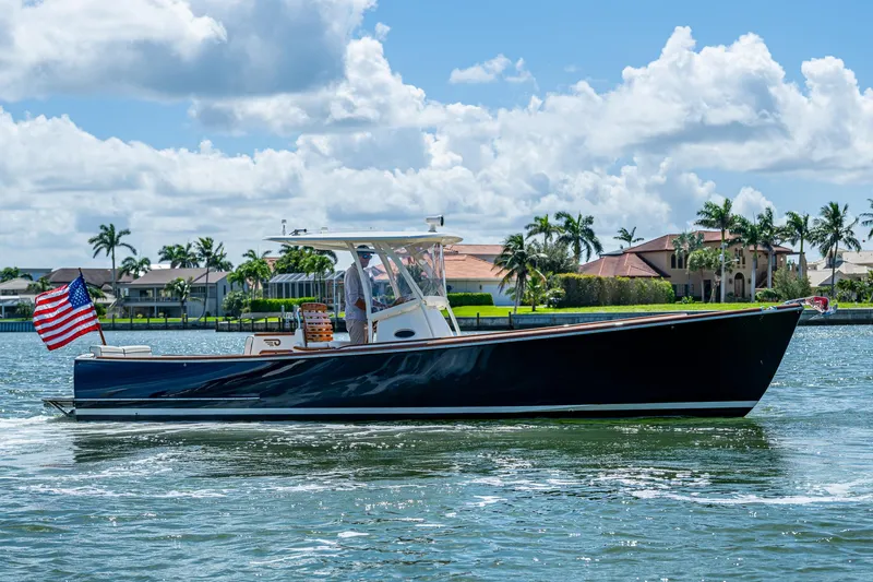 Slide: The Image of 2003 Hinckley Talaria 29 Center Console boat cruising on a sunny day, American flag displayed. - 4