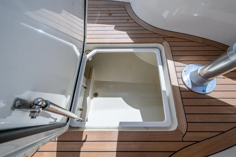 Slide: The Image of Open storage compartment on 2003 Hinckley Talaria 29 Center Console boat with teak flooring. - 11