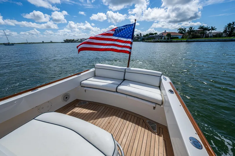 Slide: The Image of 2003 Hinckley Talaria 29 Center Console with American flag on calm waters. - 5