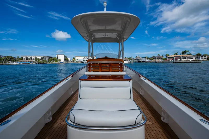 Slide: The Image of 2003 Hinckley Talaria 29 Center Console boat on water, clear sky, coastal background. - 6