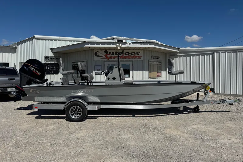 The Image of 2026 G3 21GX boat on trailer outside dealership under clear blue sky. - 1
