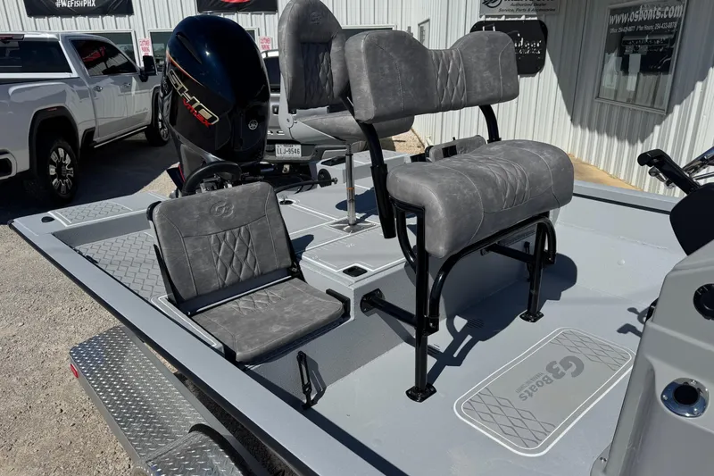 Slide: The Image of 2026 G3 21GX boat interior with gray seating and motor, parked near a building. - 10