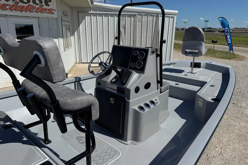 Slide: The Image of 2026 G3 21GX boat interior with steering console and seating, parked outside a building. - 9