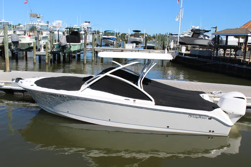 Slide: The Image of 2020 Edgewater 248CX Crossover boat docked at marina, covered and ready for use. - 13