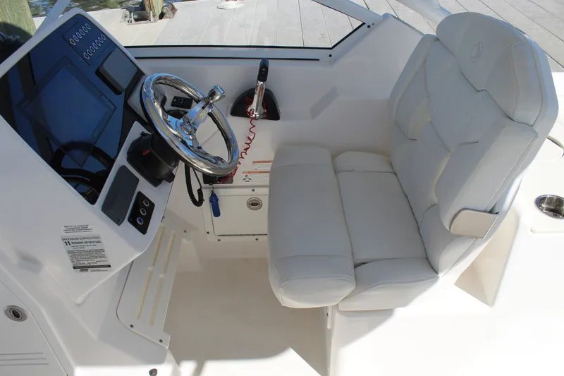 Slide: The Image of 2020 Edgewater 248CX Crossover boat cockpit with steering wheel and cushioned seat. - 29
