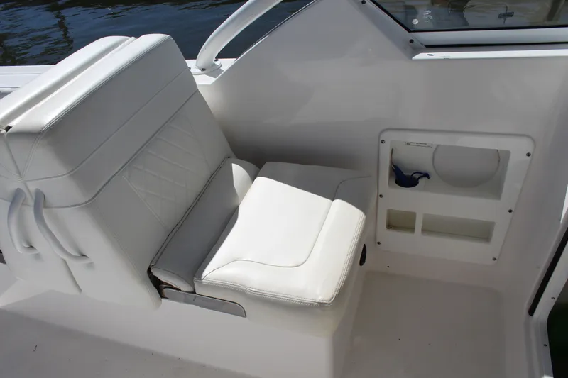 Slide: The Image of 2020 Edgewater 248CX Crossover boat interior with white seating and storage compartments. - 34
