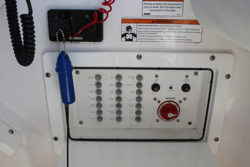 Slide: The Image of Control panel of a 2020 Edgewater 248CX Crossover boat with warning labels and switches. - 37