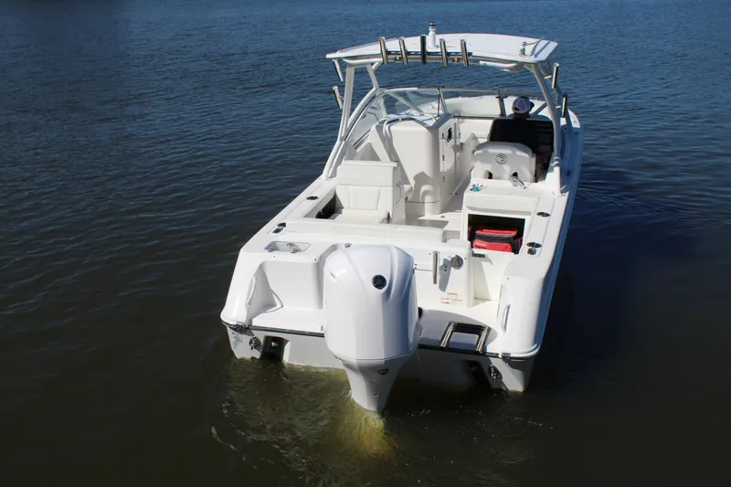 Slide: The Image of 2020 Edgewater 248CX Crossover boat on calm water, rear view. - 5