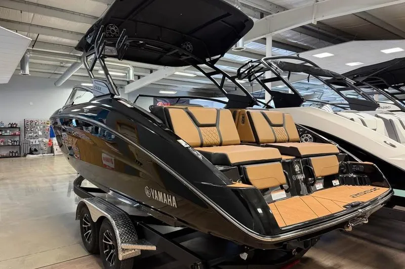 Slide: The Image of 2026 Yamaha Boats 255XD in showroom, featuring sleek black design and luxurious seating. - 3