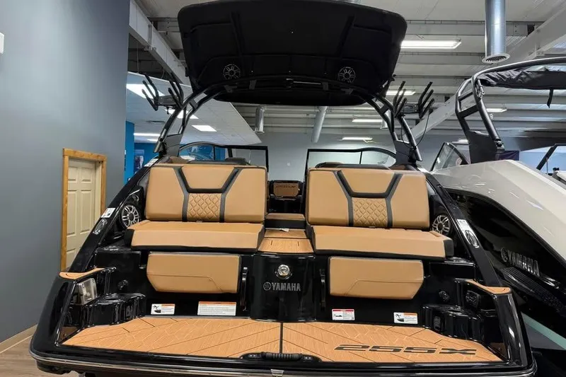 Slide: The Image of 2026 Yamaha Boats 255XD interior with tan seating and sleek design in showroom. - 5