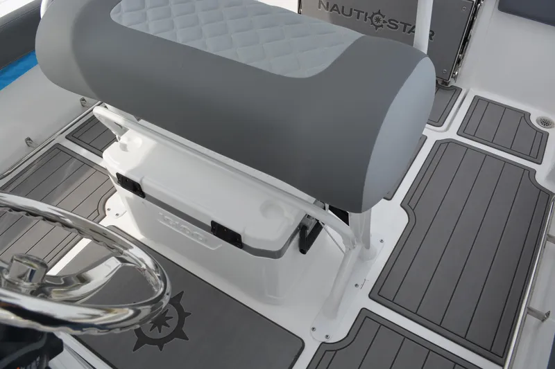 Slide: The Image of 2026 NauticStar 242 Offshore boat interior with cushioned seating and steering wheel. - 15