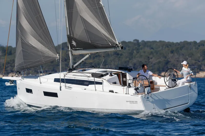 Slide: The Image of 2026 Jeanneau Sun Odyssey 350 sailing on open water with two people onboard. - 1