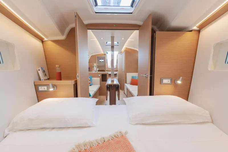 Slide: The Image of 2026 Jeanneau Sun Odyssey 350 interior cabin with modern design and cozy bedding. - 16