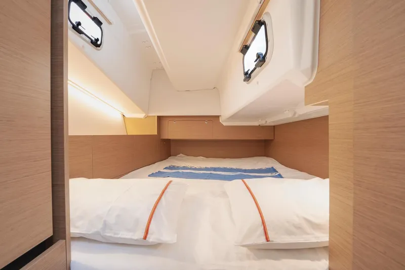 Slide: The Image of Interior cabin of 2026 Jeanneau Sun Odyssey 350 yacht, featuring cozy bedding and wooden accents. - 18
