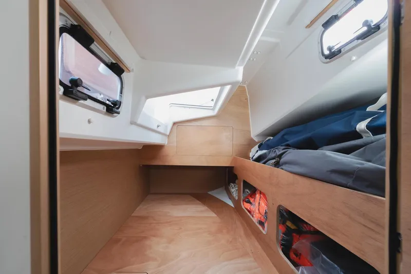 Slide: The Image of Interior cabin of 2026 Jeanneau Sun Odyssey 350 sailboat, featuring wood finish and storage. - 19