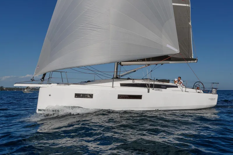 Slide: The Image of 2026 Jeanneau Sun Odyssey 350 sailing on open water under clear blue skies. - 2