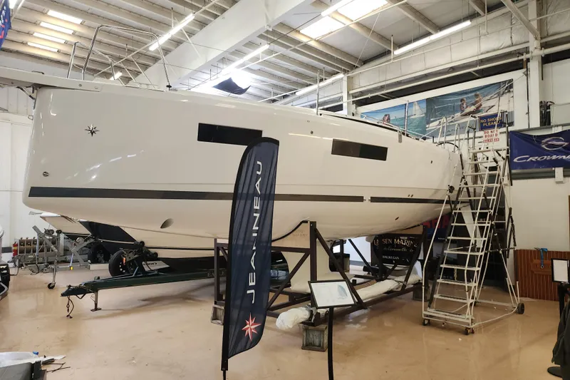 Slide: The Image of 2026 Jeanneau Sun Odyssey 350 sailboat in a showroom, displayed on a stand. - 26