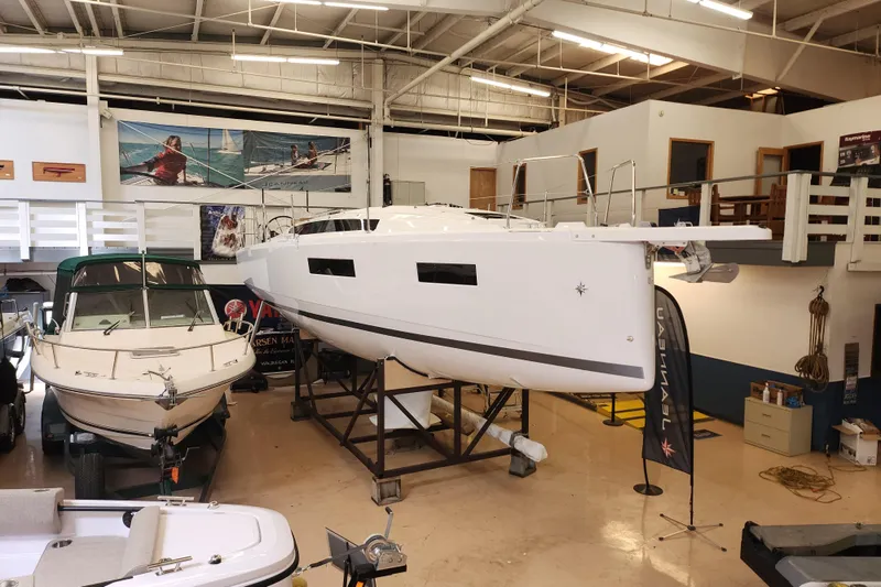 Slide: The Image of 2026 Jeanneau Sun Odyssey 350 sailboat displayed indoors, alongside other boats. - 28