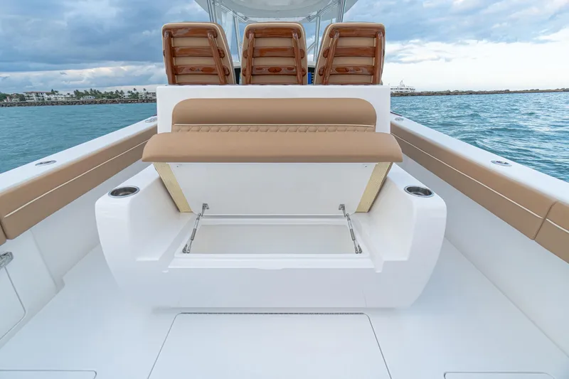 Slide: The Image of 2026 Valhalla Boatworks V-37 interior with tan seating and storage, ocean backdrop. - 19