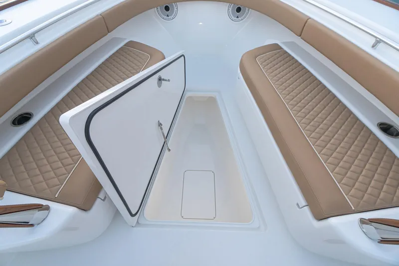 Slide: The Image of 2026 Valhalla Boatworks V-37 interior with tan quilted seating and storage compartment. - 7