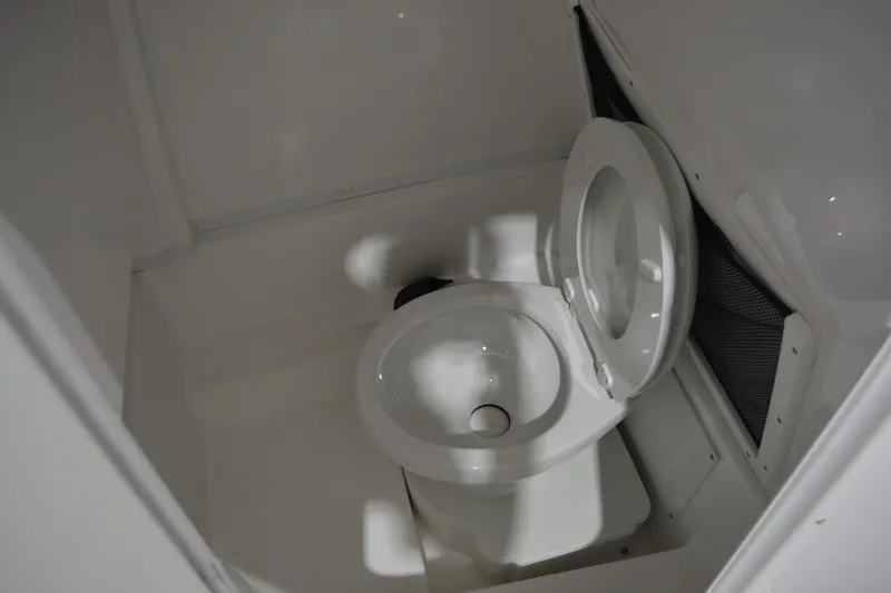 Slide: The Image of 2026 NauticStar 252 Legacy boat interior with a compact marine toilet. - 18