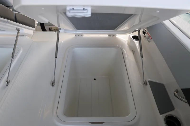 Slide: The Image of Open storage compartment on 2026 Chaparral 250 OSX boat, featuring hydraulic supports. - 15