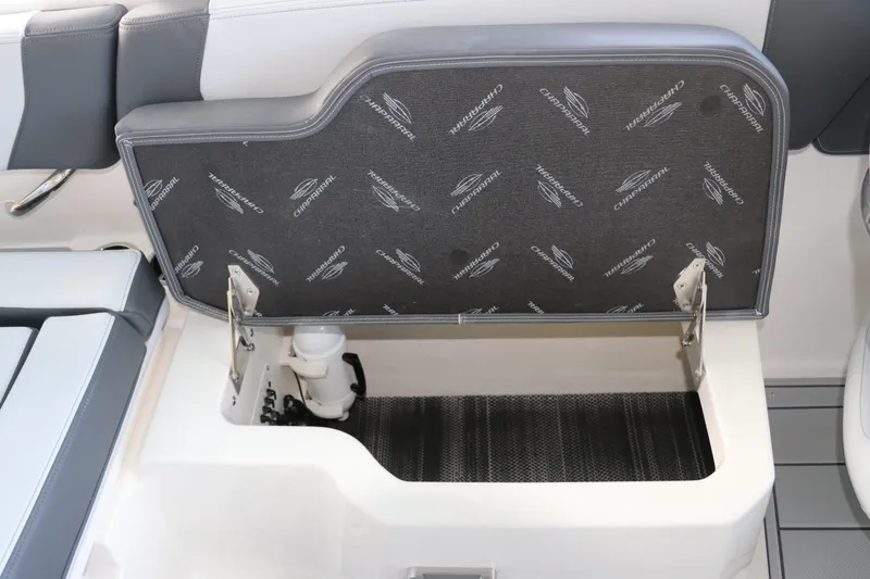 Slide: The Image of 2026 Chaparral 250 OSX boat storage compartment with branded upholstery and open lid. - 20