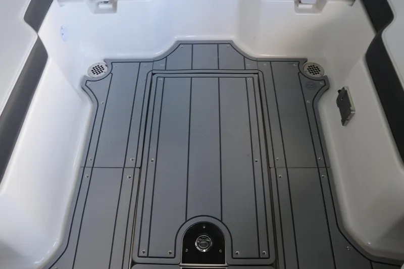 Slide: The Image of 2026 Chaparral 250 OSX boat deck with sleek gray flooring and drainage features. - 24