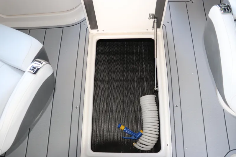 Slide: The Image of Storage compartment on 2026 Chaparral 250 OSX boat with coiled hose. - 26